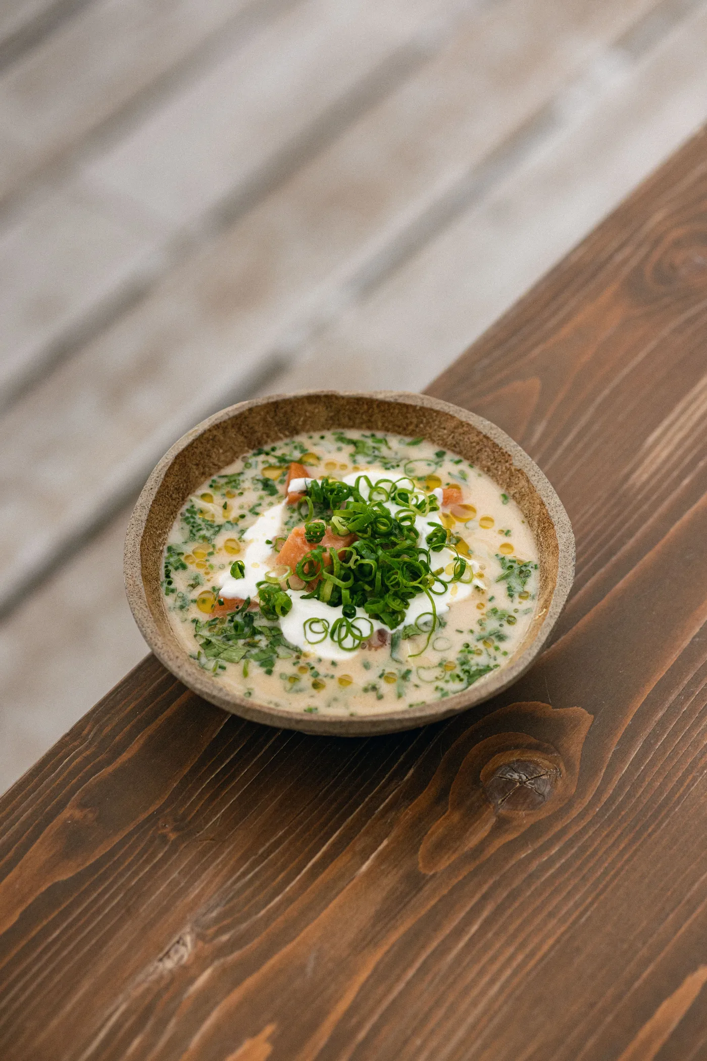 Eine Schüssel cremige Suppe mit frischen Kräutern