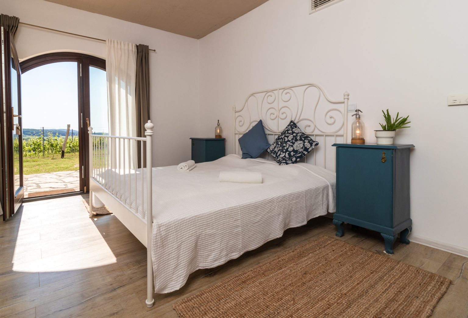 A Nest Cottage kétágyas szobája a szőlősorokra nyíló ajtóval
