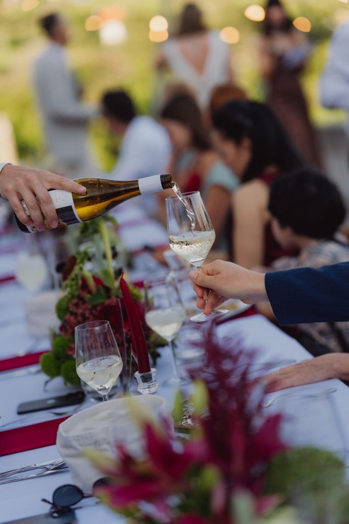 Wein, der bei einer gemeinsamen Mahlzeit im Freien ausgegossen wird